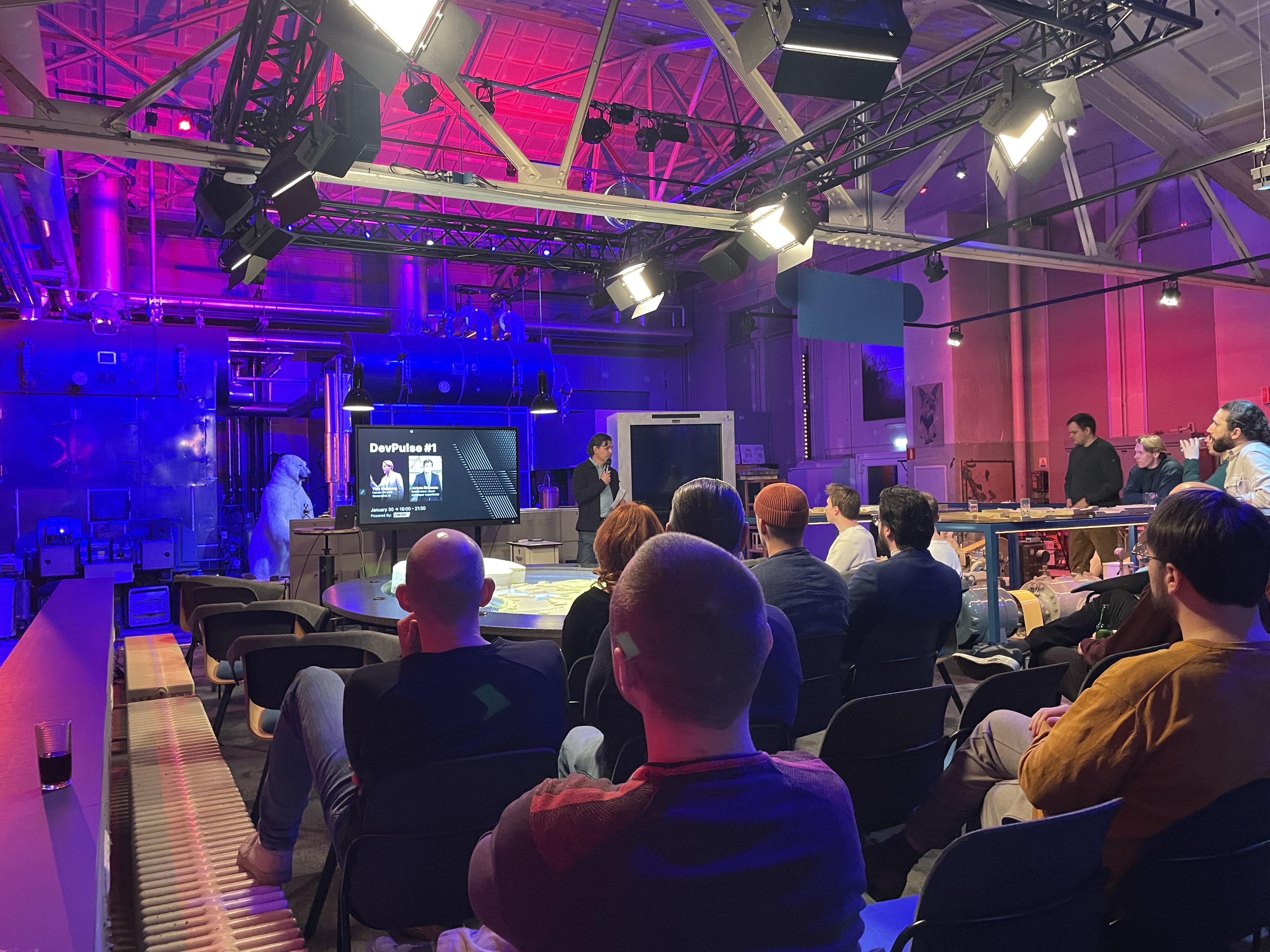 The room at DevPulse No. 1: rows of people facing the stage screen