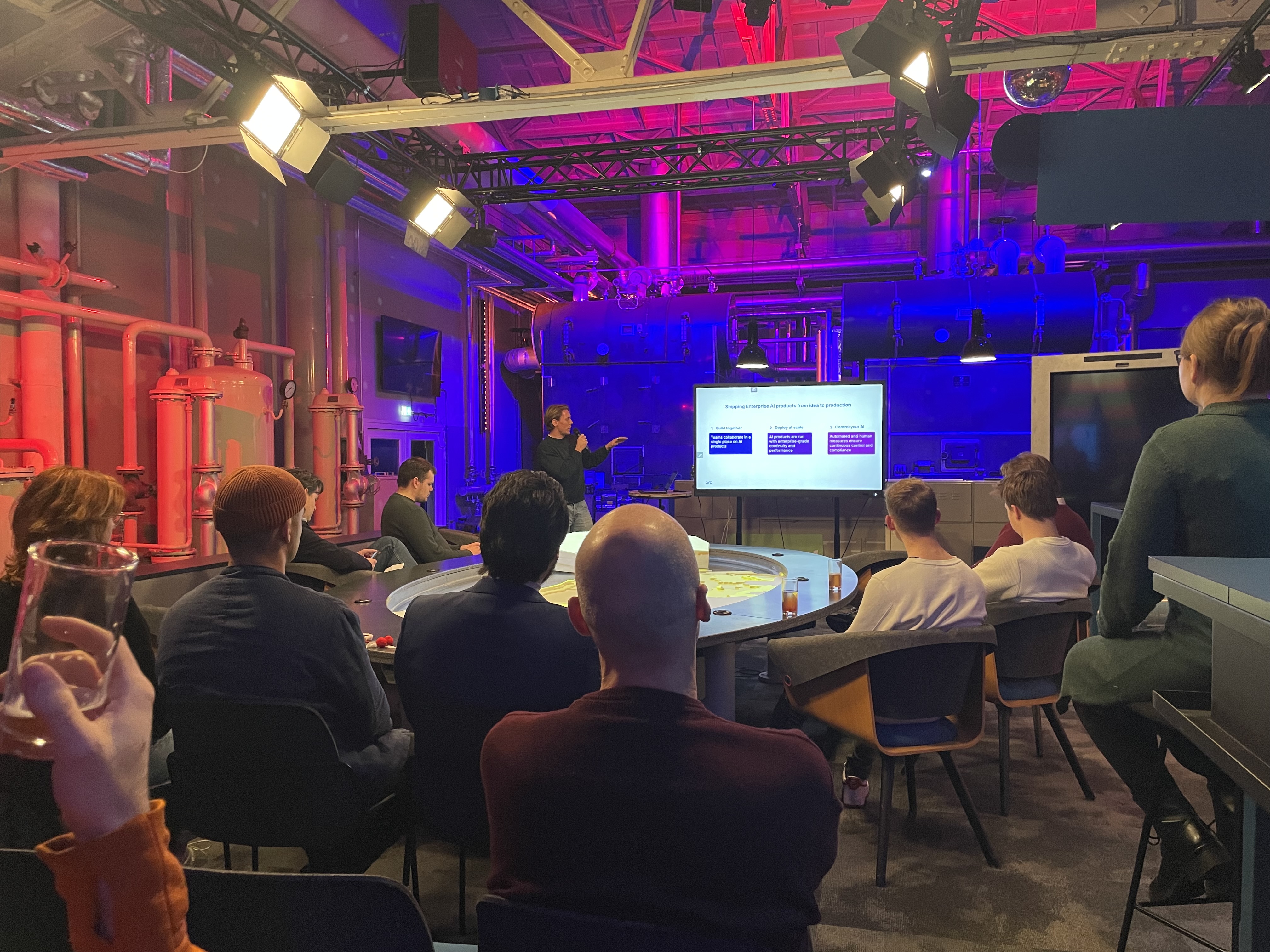 A speaker presenting at DevPulse No. 1, the audience seated around him